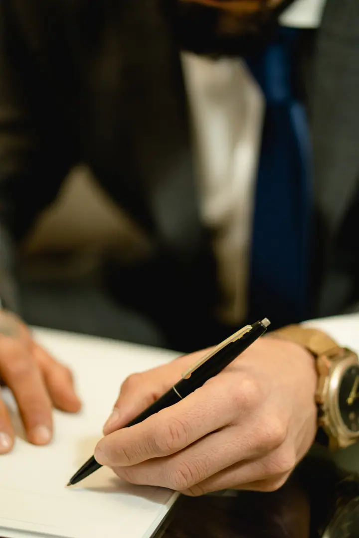 Manos firmando un documento con pluma estilográfica
